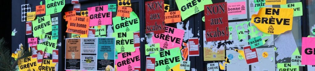 Canadian strike posters on a wall.